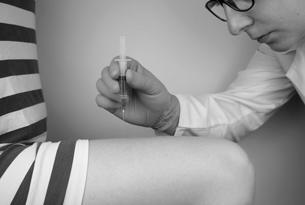 Intramuscular vitamin b12 injection into the thigh area.